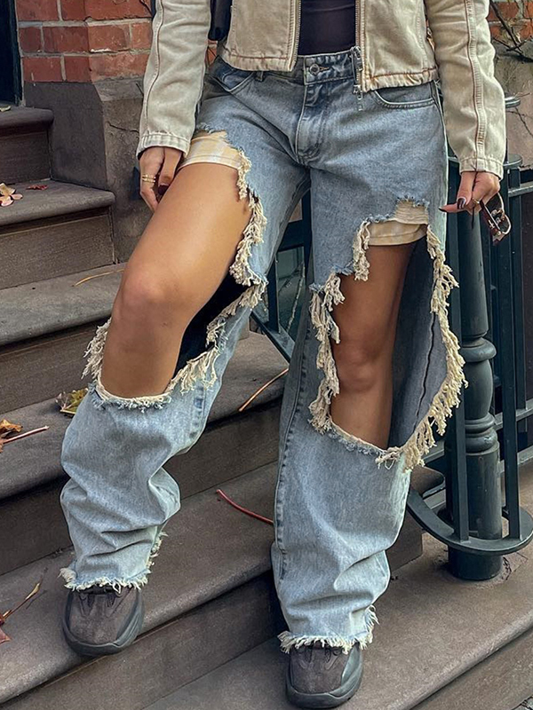 Ein großes Loch in der zerrissenen Jeans am Knie-3